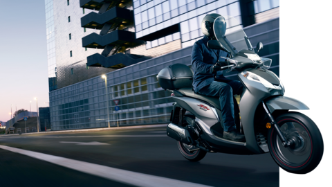 Vista dianteira a três quartos da Honda SH300i, em movimento na cidade.