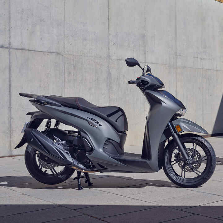 Duas Honda SH350i estáticas no exterior de um edifício. 
