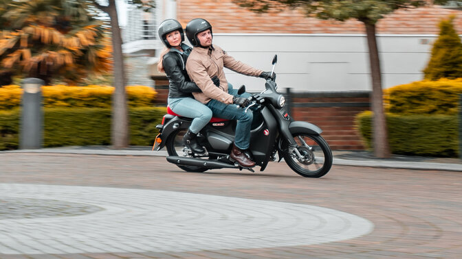 Honda Monkey sobre descanso lateral em estrada com condutor