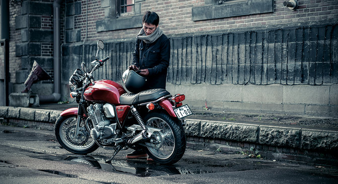 Vista traseira a três quartos da Honda CB1100EX com condutor.