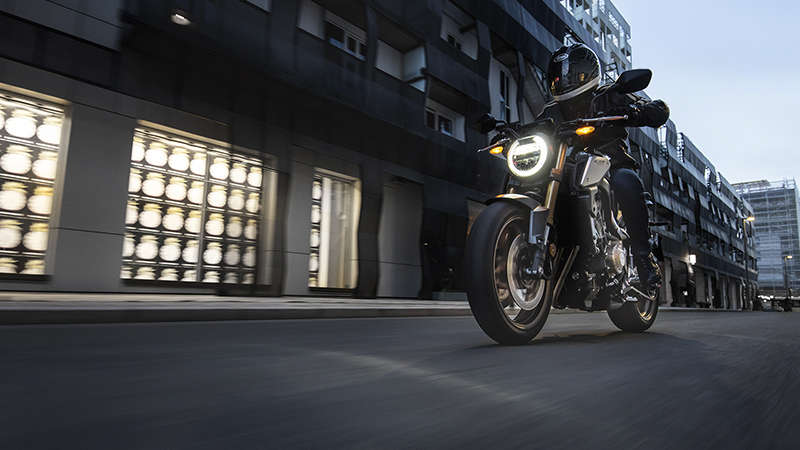 CB650R Neo Sports Café, lado esquerdo a 3 quartos com condutor, numa zona urbana