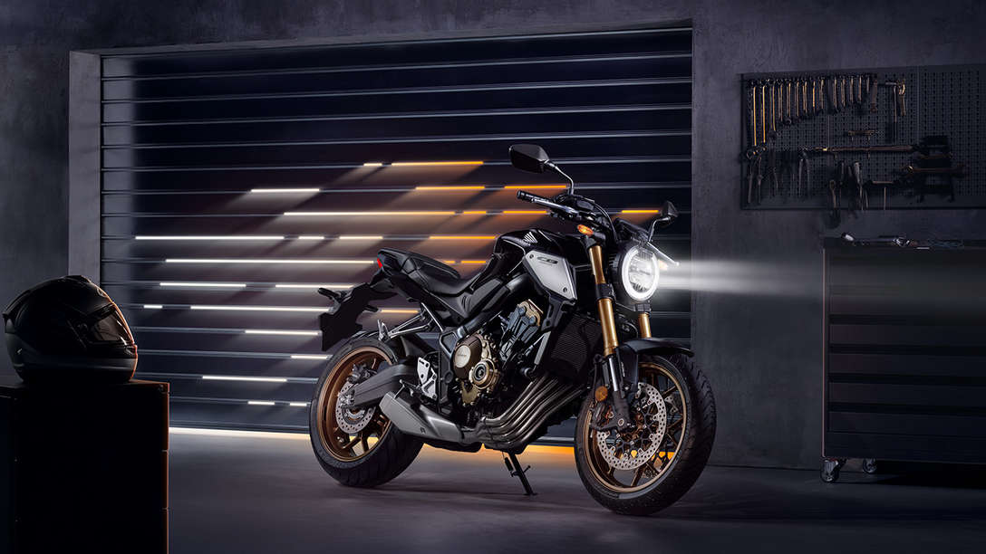CB650R Neo Sports Café, vista frontal lateral direita a 3 quartos, numa zona urbana à noite