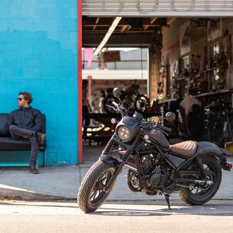 Vista lateral da Honda CMX500 Rebel estacionada &agrave; porta da oficina.