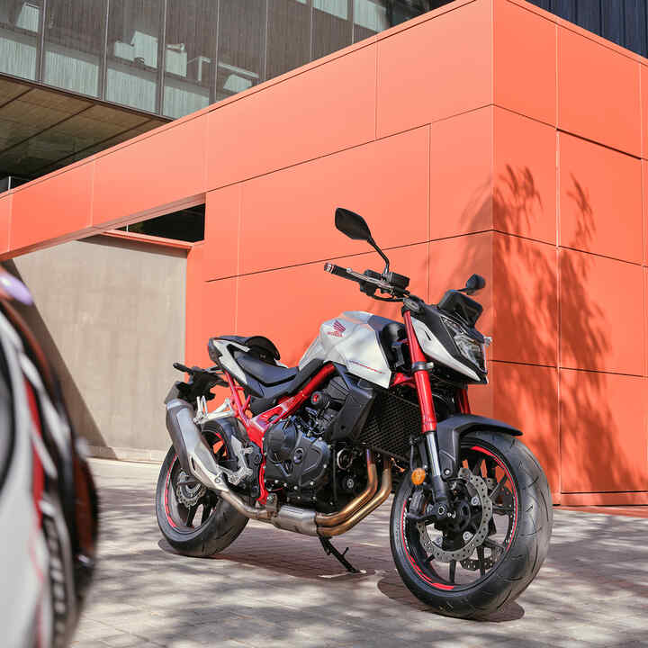 Honda CB750 Hornet em frente a um edifício laranja.