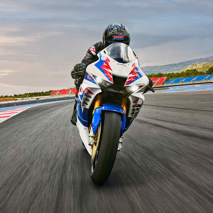 Piloto de frente para a Honda CB900RR Fireblade numa pista de corridas