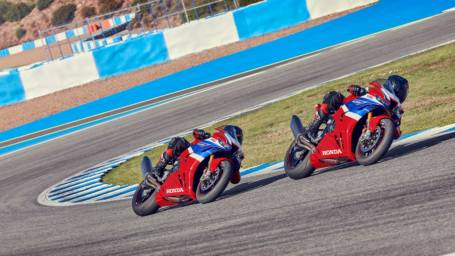 Condutor e passageiro sobre uma Honda CBR1000rr-r Fireblade em pista, em curva