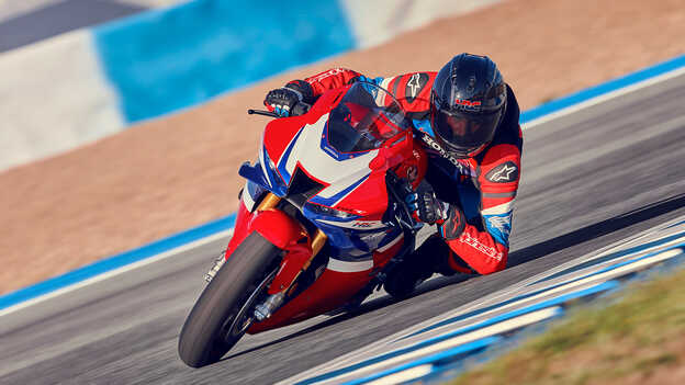 Condutor sobre uma Honda CBR1000rr-r Fireblade em pista, em curva.