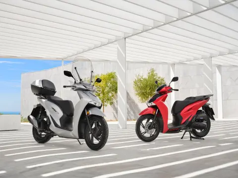 Honda SH350 com horizonte costeiro ao pôr-do-sol com condutor